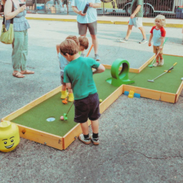 Child playing mini golf at OGteebox youth program